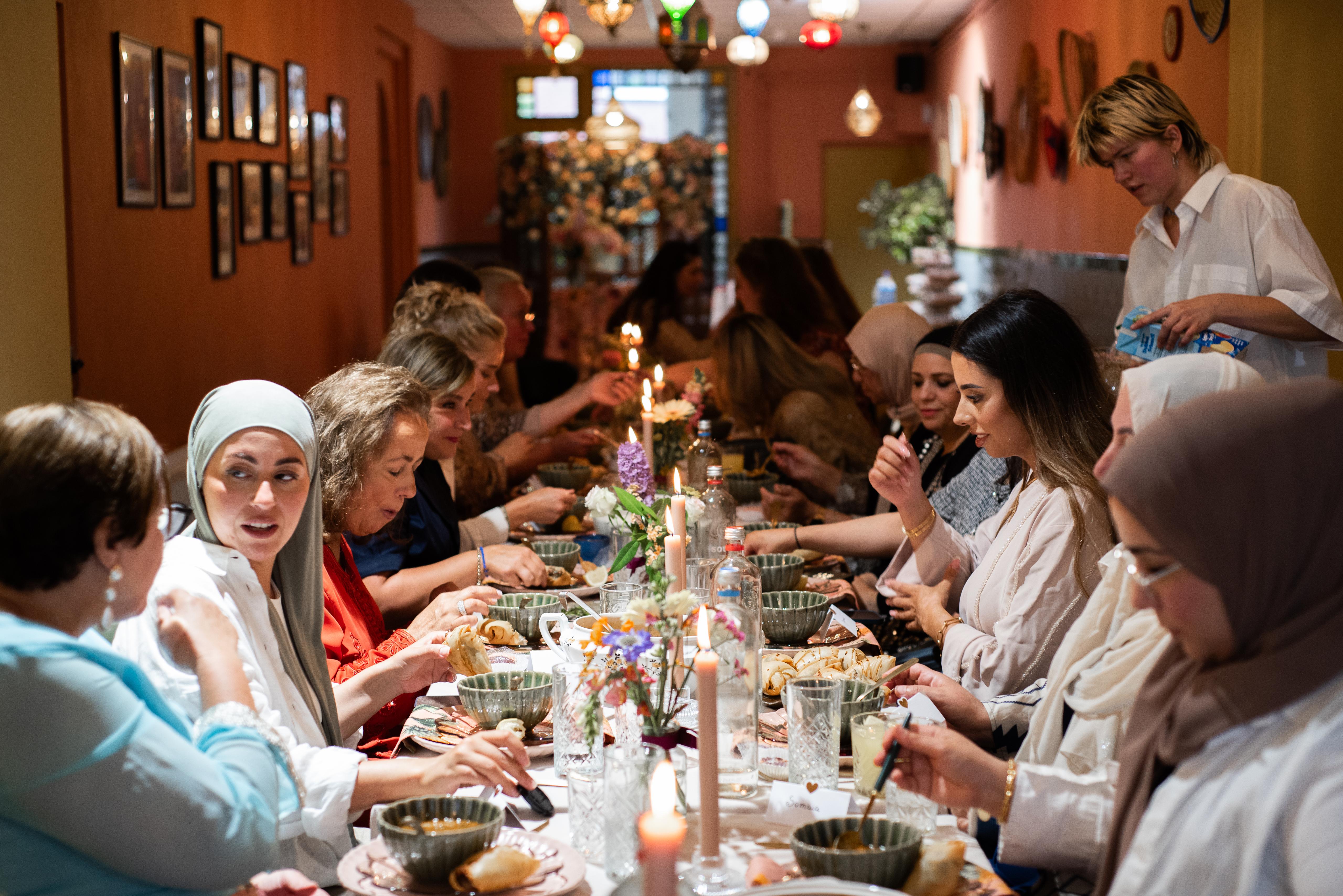 Gasten genieten samen van een maaltijd aan een feestelijk gedekte tafel